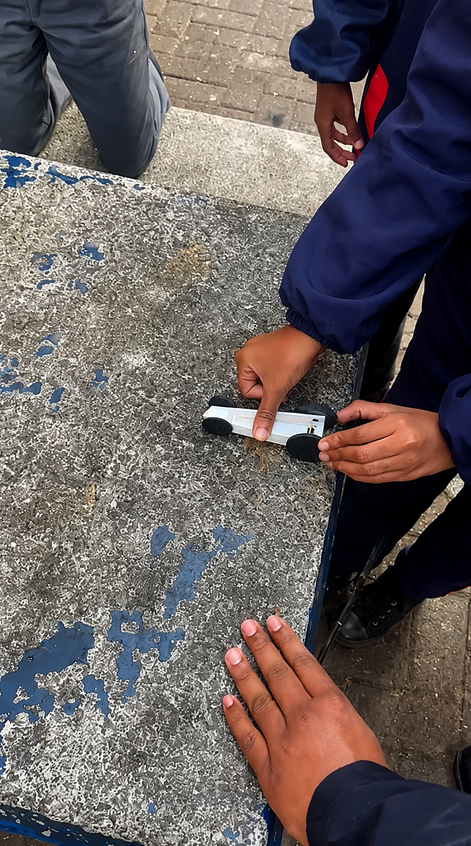 Learners exploring a small hands-on STEM car activity at Berea Primary School